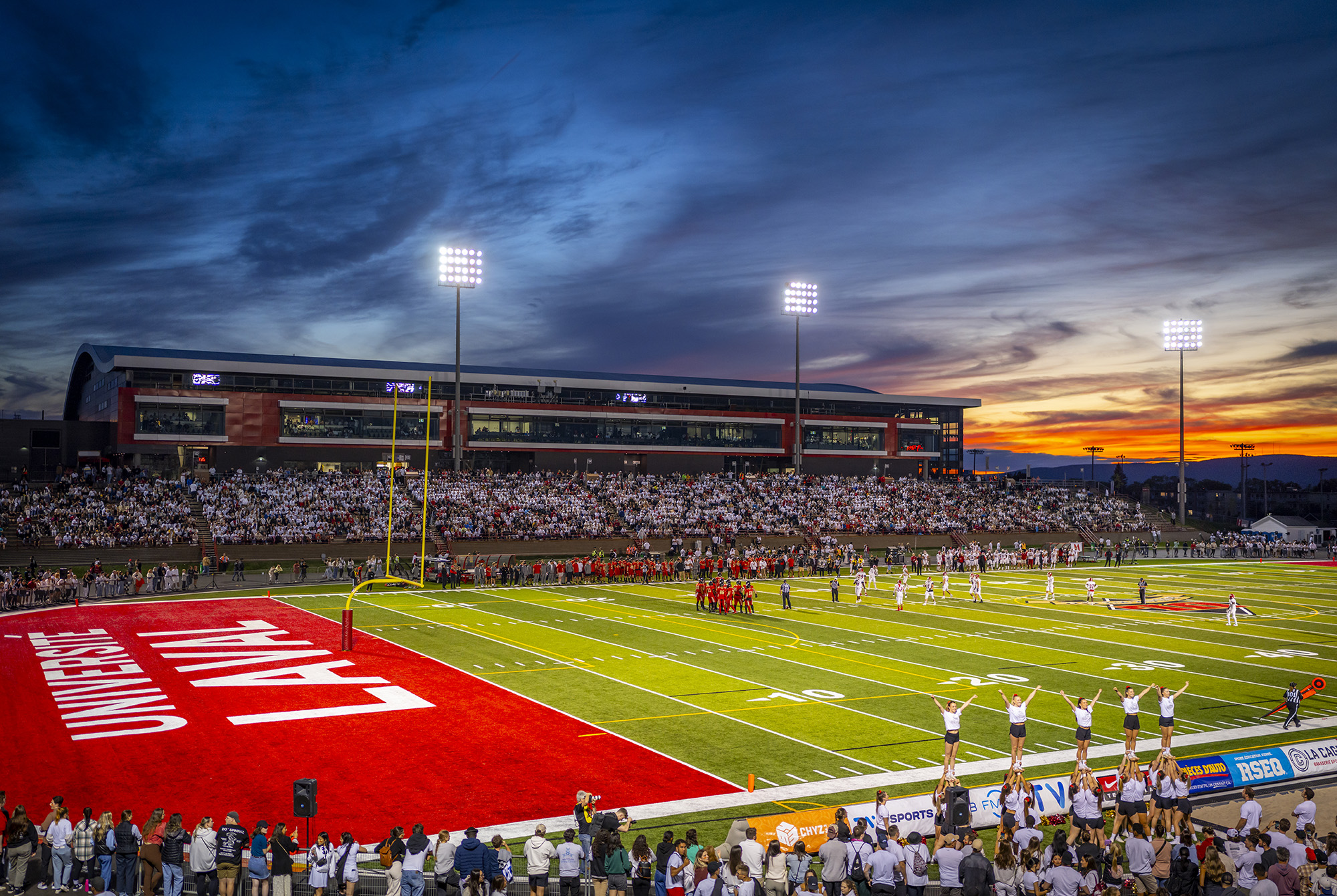 Stade de football de l'Université Laval avec équipe Rouge et Or et spectateurs lors d'un match à Québec